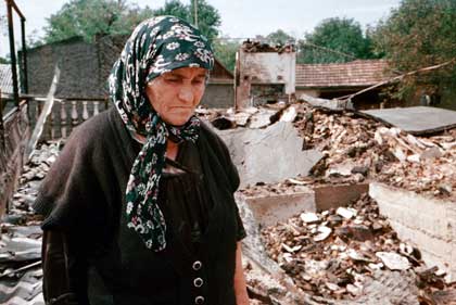 Chechen woman Aset Musayeva, 70, stands in the ruins of her home in the village of Alleroy, 70 km (about 44 miles) southeast of the Chechen capital of Grozny, Tuesday, Aug. 28, 2001.