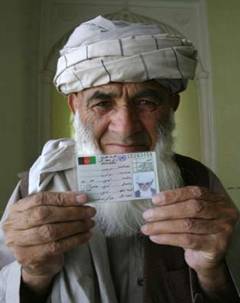 An elderly Afghan named Baedar poses with his voter identity card at a makeshift registration center in the Edgah mosque, in Kabul, July 28, 2004. President Hamid Karzai surprisingly dropped his powerful defense minister as his running mate for an October 9 presidential election, deepening the rift between him and powerful warlords. REUTERS/Ahmad Masood