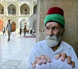 Elderly Iraqi Shi'ite man Bakka Ibrahim, 79, rests during his weekly visit to the Imam Ali shrine in Najaf August 23, 2004. All the action didn't prevent the 79-year-old man from sitting on a step and seeking spiritual comfort in the golden shrine, his weekly routine since he was a young boy. Fierce fighting broke out around the shrine and pieces of shrapnel landed in the courtyard of the mosque held by followers of a radical Shi'ite cleric. Photo by Chris Helgren/Reuters