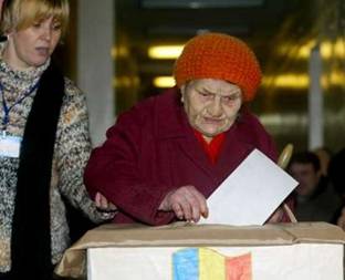 An elderly Moldovan woman is helped by a member of the electoral commission to cast her ballot at a polling station in Chisinau, March 6, 2005. Citizens of the four million ex-Soviet state cast their ballots in the country's parliamentary election today against a backdrop of alarm in Moscow that Moldova - like Ukraine and Georgia - plans to move westwards out of Russia's sphere of influence.   REUTERS/Bogdan Cristel
