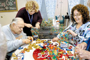 HELEN COMER/The Jackson Sun - Paul Webster, a resident at the Tennessee State Veterans Home in Humboldt, bags candy for volunteers on Friday with Christy Baughman, activity director, and Laura Waehler, activity assistant. April is volunteer appreciation month at the home, which has more than 100 volunteers who help out.