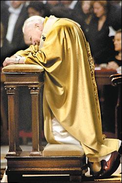 Pope John Paul II kneels before the altar inside St. Peter's Basilica during the 'Mass of the Rings' for new cardinals. Aides had lifted the pontiff from his wheelchair and placed him on the kneeler. They also assisted in reading the Pope's remarks. VICKI VALERIO / Inquirer 