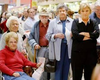 Patients wait for hours in line to receive a flu vaccine during a clinic at the Giant food market in Fairfax, Virginia, October 13, 2004. With half of the expected national supply of vaccine missing, the clinic would only administer the vaccine to people over the age of 65 or those who fell into a 'high-risk' category.  REUTERS/Larry Downing