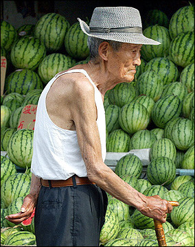 An elderly man stands in front of a watermelon stall in Shanghai. Shanghai faces a major demographic crisis as the number of its senior citizens keeps rising.(AFP/File/Liu Jin)