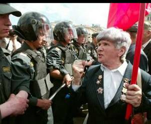 Russian pensioner shouts at police during a protest rally in central Moscow, July 2, 2004. The State Duma lower house of parliament is to give initial approval to a law replacing traditional state benefits with cash payments for millions of Russians on low incomes, including the poor, war veterans, pensioners and disabled people. REUTERS/Sergei Karpukhin