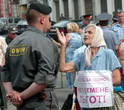 An elderly woman speaks to a riot policeman during a rally outside the Federation Council building, in Moscow, August 8, 2004. Two groups of picketers gathered outside the Federation Council on Sunday to express support or to protest against the changes in Russia's welfare system, due to replace benefits such as free transport for millions with cash handouts.     REUTERS/Sergei Karpukhin