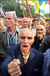 Elderly opposition supporters waving Ukrainian national yellow and blue flags and chanting anti-government slogans, take part in an action of protest to demand the ouster of President Leonid Kuchma in downtown Kiev, Ukraine, on Monday, Sept. 16, 2002. Tens of thousands of protesters take to the streets across Ukraine to participate in one of the largest demonstrations since Ukraine's independence from the Soviet Union. (AP Photo/Viktor Pobedinsky)
