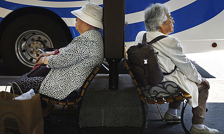 Elderly Japanese people sit on benches to stay out of the scorching sun as they wait for a bus in Tokyo. Photograph: Junji Kurokawa/AP