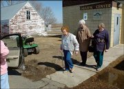 From left, Gladys Wick, Mary Wick and Elsie Whitman walk from the
Robinson Senior Center to a volunteer chauffeur waiting to give
them a ride home. The three had just eaten lunch at the center in
Robinson, N.D.