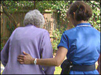 A nurse helping an elderly lady