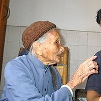 Chinese Grandma in pictures of old people gives some advice to a younger man in Longzhou.
