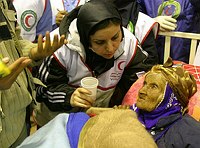 An Iranian woman Shahrbanoo Mazandarani (
R) was pulled alive and unscathed from 
the rubble in Bam on January 3, 2004 
more than eight full days after an 
earthquake destroyed the city, receives 
treatment at a field hospital. The woman,
 believed to be in her 90s, was found in 
good condition despite long odds of 
surviving so long after the quake. She 
was located first by sniffer dogs on 
Saturday afternoon -- more than 8-1/2 
days after the quake buried her under a 
building.     REUTERS/Morteza 
Nikoubazl
