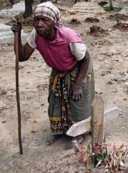 Malawian bent over old woman with cane in graveyard by Hege Opseth.