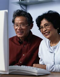 Two older adults using a computer.