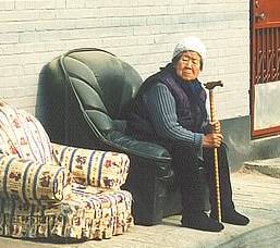 Pictures of Old People: Chinese woman in Beijing Hutong sits in armchair.