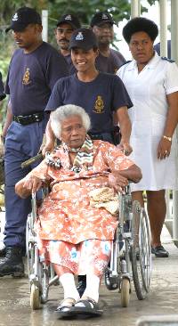 Home resident Siteri Yabaki, 77, is taken around by Josivini Soqo as fellow members of the Police Tactical Response unit look on during a clean up campaign at the home