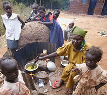 An older Kenyan woman feeds her orphaned grandchildren. Photo: Kate Holt/HelpAge International.