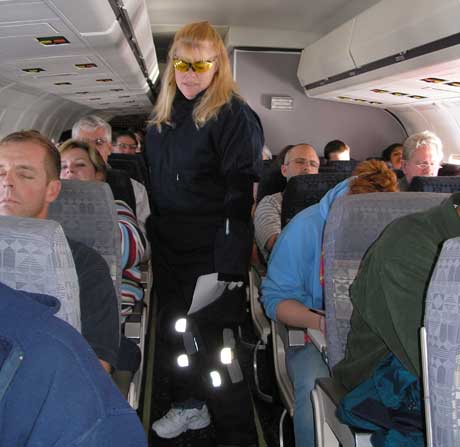 Dolores Lystad, a functional test engineer in Everett, Wash., walks slowly down an airplane aisle wearing a "Third Age Suit" that allows users to experience the limitations felt by many older individuals.
