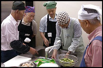 Retired banker Tomohisa Kotake, second from left, participates in a cooking class at a Men in the Kitchen support group meeting in western Tokyo.